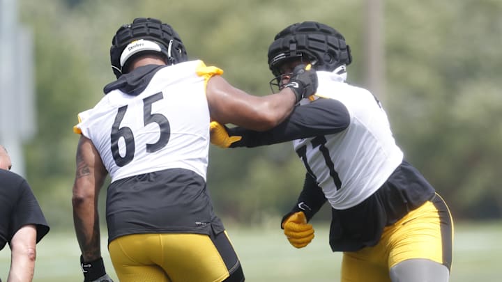 Jul 27, 2023; Latrobe, PA, USA;  Pittsburgh Steelers offensive tackle Dan Moore Jr. (65) works against offensive tackle Broderick Jones (77) in drills during training camp at Saint Vincent College. Mandatory Credit: Charles LeClaire-Imagn Images