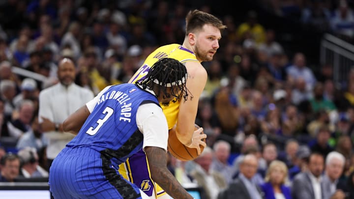 Mar 24, 2025; Orlando, Florida, USA; Los Angeles Lakers guard Luka Doncic (77) is guarded by Orlando Magic guard Kentavious Caldwell-Pope (3) at Kia Center. Mandatory Credit: Nathan Ray Seebeck-Imagn Images