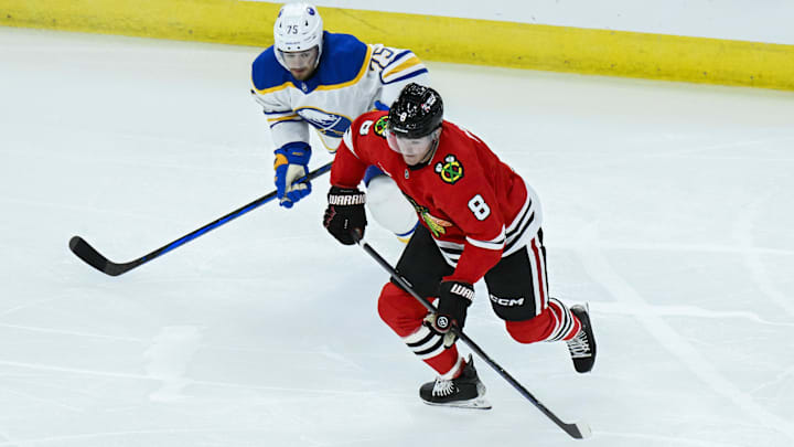 Oct 19, 2024; Chicago, Illinois, USA;  Chicago Blackhawks center Ryan Donato (8) moves the puck against Buffalo Sabres defenseman Connor Clifton (75) during the third period at the United Center. Mandatory Credit: Matt Marton-Imagn Images