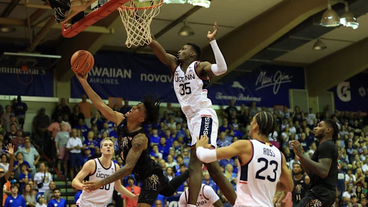 Nov 25, 2024; Lahaina, Hawaii, USA; Memphis Tigers guard PJ Haggerty (4) tries for the basket while being guarded by Connecticut Huskies center Samson Johnson (35)  in the second half of an NCAA college basketball game at Lahaina Civic Center. Mandatory Credit: Marco Garcia-Imagn Images