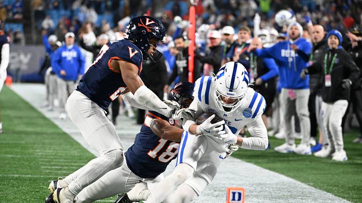 Dec 6, 2025; Charlotte, NC, USA; Duke Blue Devils wide receiver Cooper Barkate (18) catches a pass near the goal line as Virginia Cavaliers safety Devin Neal (27) and safety Corey Costner (18) defend in the fourth quarter during the ACC Championship game at Bank of America Stadium. Mandatory Credit: Bob Donnan-Imagn Images Dec 6, 2025; Charlotte, NC, USA; Duke Blue Devils wide receiver Cooper Barkate (18) catches a pass near the goal line as Virginia Cavaliers safety Devin Neal (27) and safety Corey Costner (18) defend in the fourth quarter during the ACC Championship game at Bank of America Stadium. Mandatory Credit: Bob Donnan-Imagn Images