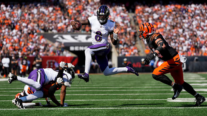 Baltimore Ravens quarterback Lamar Jackson (8) leaps away from Cincinnati Bengals defensive end Sam Hubbard (94) in the first quarter of the NFL Week 5 game between the Cincinnati Bengals and Baltimore Ravens at Paycor Stadium in Cincinnati on Oct. 6, 2024.