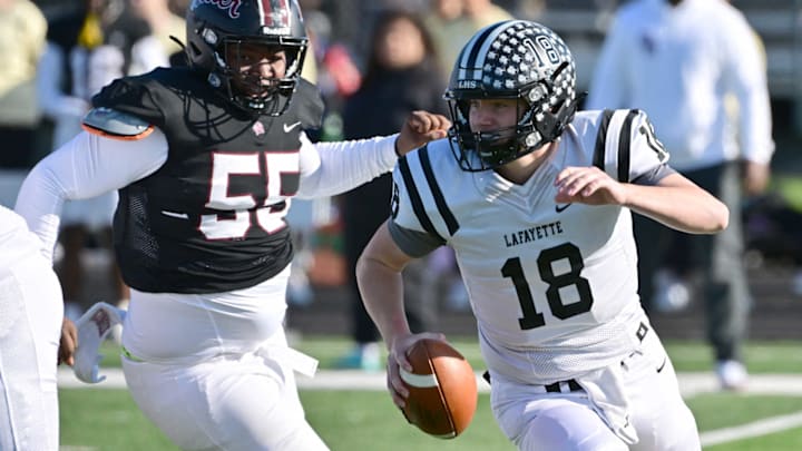 Lafayette (Wildwood) quarterback Jack Behl runs away from Cardinal Ritter defender Jocquez Felix in a game last week.