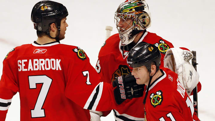 Mar 5, 2010; Chicago, IL, USA; Chicago Blackhawks goalie Cristobal Huet (top right) is congratulated by teammates Brent Seabrook (7) and John Madden (11) after defeating teh Vancouver Canucks 6-3 at the United Center. Mandatory Credit: Jerry Lai-Imagn Images
