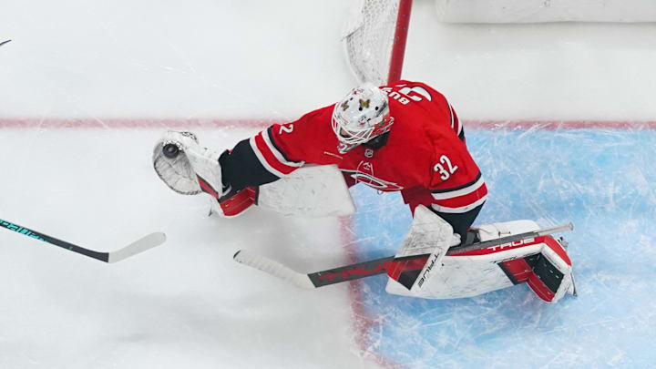 Dec 14, 2025; Raleigh, North Carolina, USA; Carolina Hurricanes goaltender Brandon Bussi (32) makes a glove save against the Philadelphia Flyers during the second period at Lenovo Center. Mandatory Credit: James Guillory-Imagn Images
