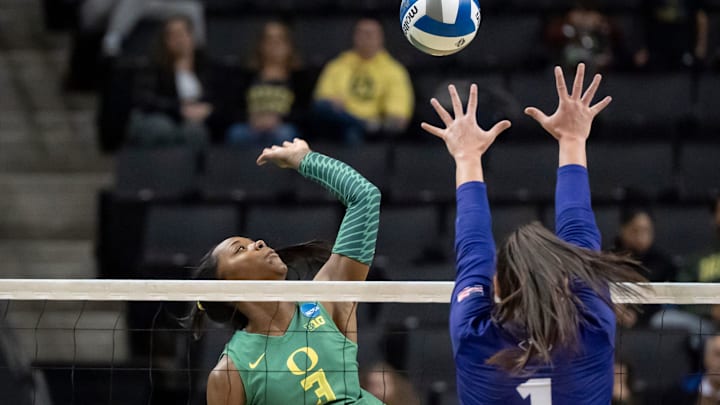 Oregon opposite Noemie Glover hits as High Point outside hitter Dylan Maberry defends as the Oregon Ducks host High Point in the first round of the NCAA volleyball tournament Thursday, Dec. 5, 2024, at Matthew Knight Arena in Eugene, Ore.