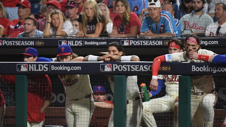 Oct 5, 2024; Philadelphia, PA, USA; Philadelphia Phillies players look out from the dugout in the ninth inning against the New York Mets in game one of the NLDS for the 2024 MLB Playoffs at Citizens Bank Park. Mandatory Credit: Eric Hartline-Imagn Images