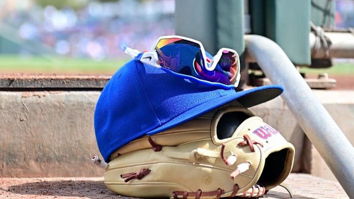 Feb 27, 2024; Mesa, Arizona, USA;  General view of a Chicago Cubs glove, hat and glasses in the first inning against the Cincinnati Reds during a spring training game at Sloan Park. Mandatory Credit: Matt Kartozian-Imagn Images