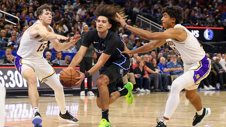 Orlando Magic guard Anthony Black (0) drives between Los Angeles Lakers guard Austin Reaves (15) and guard Max Christie (10) during the second half at Amway Center.