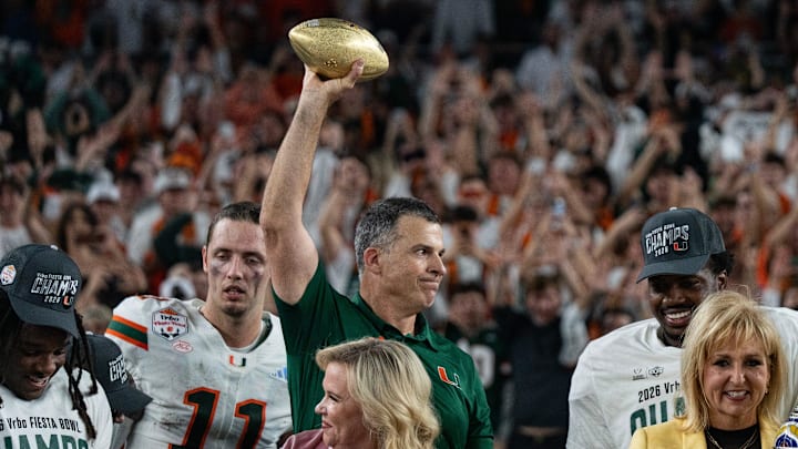 Miami Hurricanes head coach Mario Cristobal holds up the trophy after winning the CFP Fiesta Bowl against Ole Miss at the State Farm Stadium, in Glendale, Ariz., on Thursday, Jan. 8, 2026.