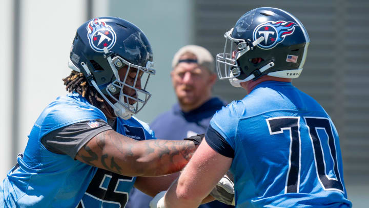 Offensivle lineman JC Latham (55) and Cole Spencer (70) run drills during Tennessee Titans practice at Ascension Saint Thomas Sports Park in Nashville, Tenn., Tuesday, May 21, 2024.