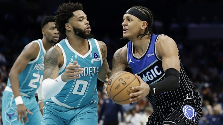 Mar 19, 2026; Charlotte, North Carolina, USA; Orlando Magic forward Paolo Banchero (5) tries to drive to the basket past Charlotte Hornets forward Miles Bridges (0) during the third quarter at Spectrum Center. Mandatory Credit: Brian Westerholt-Imagn Images