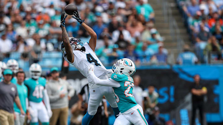 Carolina Panthers wide receiver Tetairoa McMillan (4) reaches for a pass with Miami Dolphins cornerback Jack Jones (23) defending during the third quarter at Bank of America Stadium.