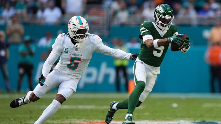 Dec 8, 2024; Miami Gardens, Florida, USA; New York Jets wide receiver Garrett Wilson (5) runs with the ball away from Miami Dolphins cornerback Jalen Ramsey (5) during the first half at Hard Rock Stadium. Dec 8, 2024; Miami Gardens, Florida, USA; New York Jets wide receiver Garrett Wilson (5) runs with the ball away from Miami Dolphins cornerback Jalen Ramsey (5) during the first half at Hard Rock Stadium.