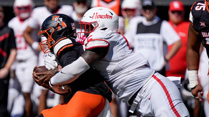 Houston Cougars defensive lineman Carlos Allen (5) brings down Oklahoma State Cowboys quarterback Sam Jackson V (18) during a college football game between the Oklahoma State Cowboys (OSU) and the Houston Cougars at Boone Pickens Stadium in Stillwater, Okla., Saturday, Oct. 11, 2025. Houston won 39-17.