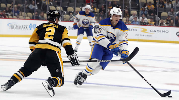 Sep 28, 2023; Pittsburgh, Pennsylvania, USA; Buffalo Sabres center Jiri Kulich (20) moves the puck against Pittsburgh Penguins defenseman Chad Ruhwedel (2) during the first period at PPG Paints Arena. Mandatory Credit: Charles LeClaire-Imagn Images
