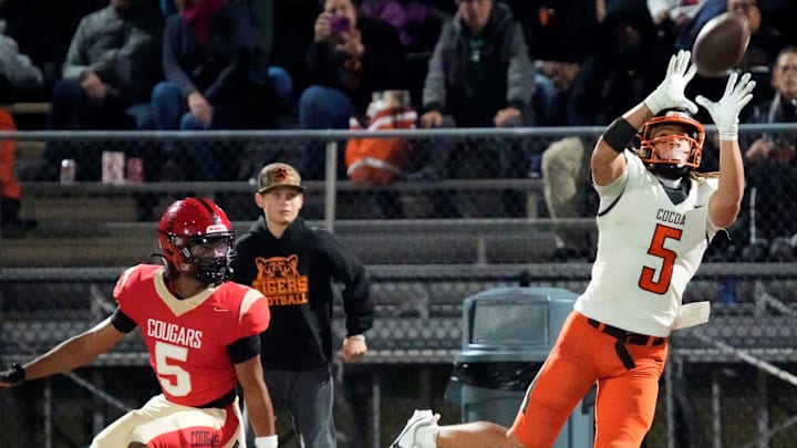 Cocoa High wide receiver Jayvan Boggs (#5) pulls in a pass along the sideline. Cocoa High School defeated Cardinal Mooney Catholic High School 31-21 to win the Class 2A semi-final game Friday night in Sarasota.