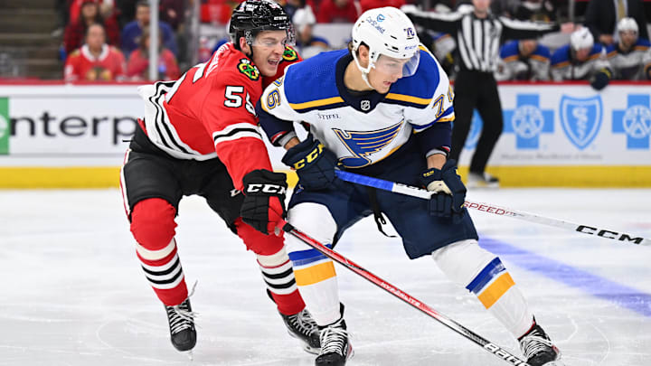 Sep 28, 2023; Chicago, Illinois, USA; Chicago Blackhawks defenseman Kevin Korchinski (55) defends against St. Louis Blues forward Zachary Bolduc (76) in the second period at United Center. Mandatory Credit: Jamie Sabau-Imagn Images