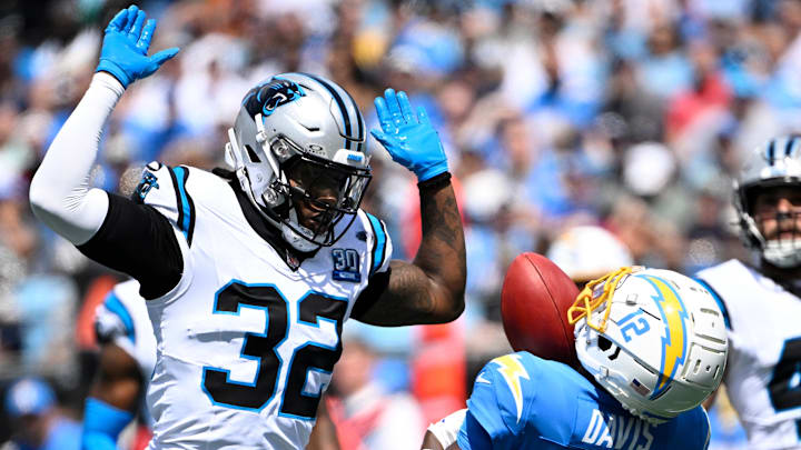 Sep 15, 2024; Charlotte, North Carolina, USA; Carolina Panthers cornerback Lonnie Johnson Jr. (32) pressures as Los Angeles Chargers wide receiver Derius Davis (12) attempts to catch a punt in the first quarter at Bank of America Stadium. Mandatory Credit: Bob Donnan-Imagn Images