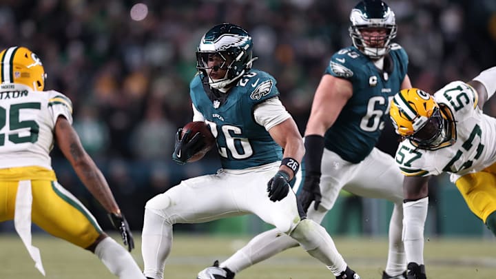 Jan 12, 2025; Philadelphia, Pennsylvania, USA; Philadelphia Eagles running back Saquon Barkley (26) rushes the ball against Green Bay Packers cornerback Keisean Nixon (25) in the fourth quarter in an NFC wild card game at Lincoln Financial Field. Mandatory Credit: Bill Streicher-Imagn Images