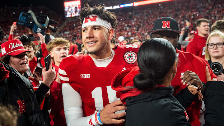 Nov 23, 2024; Lincoln, Nebraska, USA; Nebraska Cornhuskers quarterback Dylan Raiola (15) walks off as fans rush the field after defeating the Wisconsin Badgers at Memorial Stadium. Mandatory Credit: Dylan Widger-Imagn Images