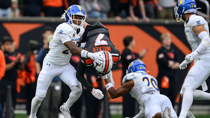Nov 9, 2024; Corvallis, Oregon, USA; Oregon State Beavers wide receiver Trent Walker (7) is upended by San Jose State Spartans defensive back Michael Dansby (25) and defensive back Isiah Revis (20) after a catch during the third quarter at Reser Stadium. Mandatory Credit: Craig Strobeck-Imagn Images