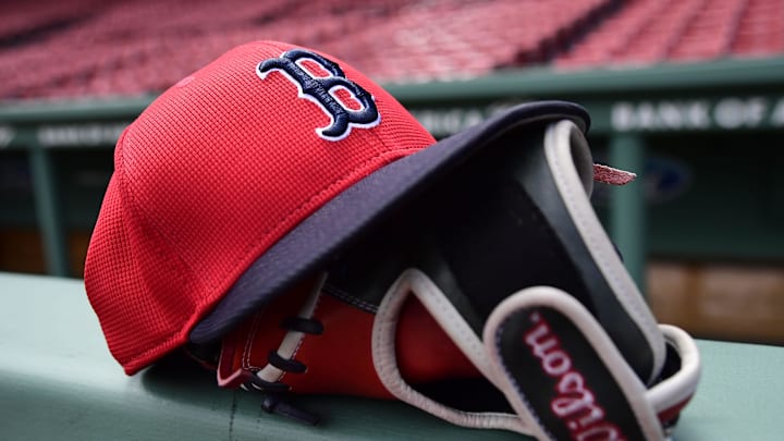 May 18, 2025; Boston, Massachusetts, USA;  A Boston Red Sox hat and glove rests on the railing by the dugout prior to a game against the Atlanta Braves at Fenway Park. Mandatory Credit: Bob DeChiara-Imagn Images