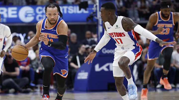 New York Knicks guard Brunson dribbles as he's defended by Detroit Pistons guard Schroder in the first half during game three of first round for the 2024 NBA Playoffs at Little Caesars Arena. 