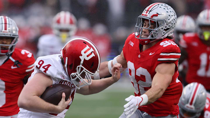 Indiana Hoosiers punter James Evans (94) is tackled after recovering his fumble by Ohio State Buckeyes defensive end Caden Curry (92) and cornerback Lorenzo Styles Jr. (3) during the second quarter at Ohio Stadium. Indiana Hoosiers punter James Evans (94) is tackled after recovering his fumble by Ohio State Buckeyes defensive end Caden Curry (92) and cornerback Lorenzo Styles Jr. (3) during the second quarter at Ohio Stadium.