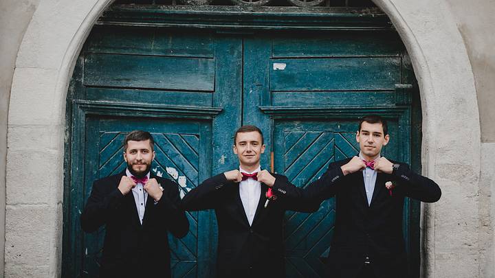 Groomsmen preparing in front of a blue door Groomsmen preparing in front of a blue door