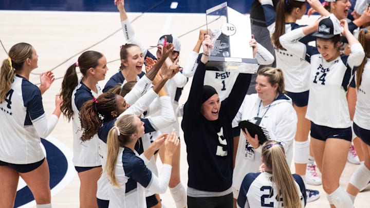 Penn State volleyball head coach Katie Schumacher-Cawley holds up the Big Ten title trophy.