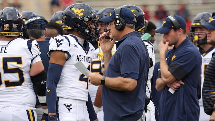 Nov 1, 2025; Houston, Texas, USA; West Virginia Mountaineers head coach Rich Rodriguez talks to wide receiver Cam Vaughn (4) during an official timeout against the Houston Cougars in the first half at TDECU Stadium. Nov 1, 2025; Houston, Texas, USA; West Virginia Mountaineers head coach Rich Rodriguez talks to wide receiver Cam Vaughn (4) during an official timeout against the Houston Cougars in the first half at TDECU Stadium.