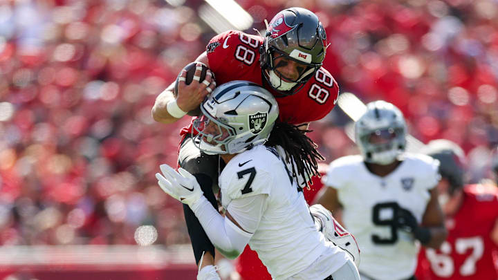 Dec 8, 2024; Tampa, Florida, USA; Tampa Bay Buccaneers tight end Cade Otton (88) is stopped by Las Vegas Raiders safety Tre'von Moehrig (7) in the first quarter at Raymond James Stadium. Mandatory Credit: Nathan Ray Seebeck-Imagn Images