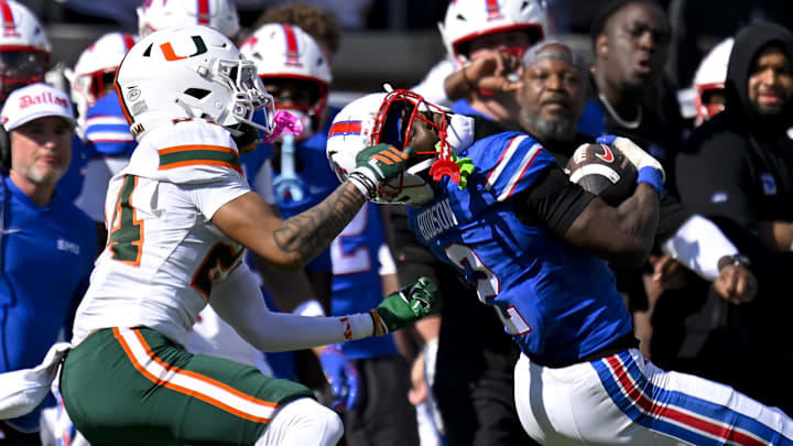 Nov 1, 2025; Dallas, Texas, USA;  SMU Mustangs wide receiver Jordan Hudson (2) catches a pass for a first down as he is tackled by Miami Hurricanes defensive back Ethan O'Connor (24) during the second half at Gerald J. Ford Stadium. Mandatory Credit: Jerome Miron-Imagn Images
