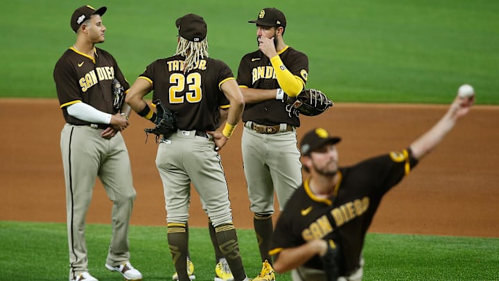 Oct 7, 2020; Arlington, Texas, USA; San Diego Padres third baseman Manny Machado (13) and shortstop Fernando Tatis Jr. (23) and first baseman Eric Hosmer (30) talk as relief pitcher Drew Pomeranz (15) warms up during the seventh inning in game two of the 2020 NLDS against the Los Angeles Dodgers at Globe Life Field. Mandatory Credit: Kevin Jairaj-USA TODAY Sports