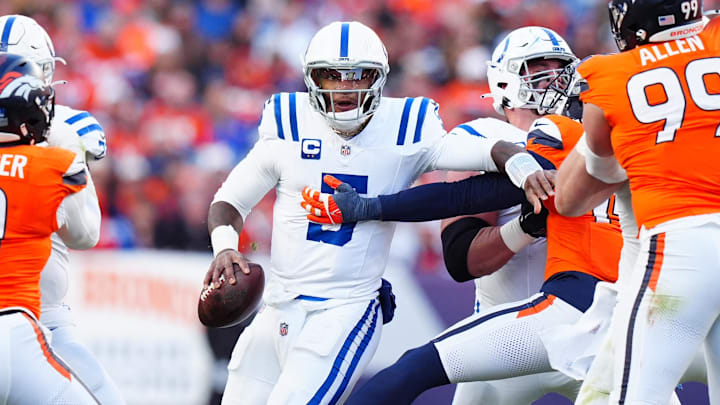 Dec 15, 2024; Denver, Colorado, USA; Denver Broncos linebacker Nik Bonitto (15) reaches for Indianapolis Colts quarterback Anthony Richardson (5) in the first half at Empower Field at Mile High. Mandatory Credit: Ron Chenoy-Imagn Images