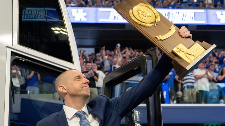 Mark Pope exits the bus with holding a trophy as he enters Rupp Arena greeting thousands of fans for his introductory press conference on Sunday, April 14, 2024.