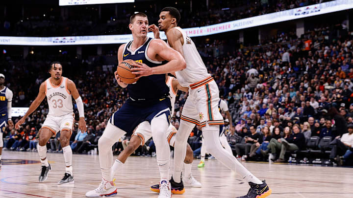 Nov 26, 2023; Denver, Colorado, USA; Denver Nuggets center Nikola Jokic (15) controls the ball as Victor Wembanyama defends