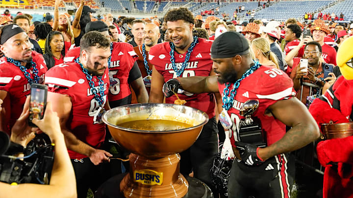 Dec 23, 2025; Boca Raton, FL, USA; Louisville Cardinals players celebrate after defeating the Toledo Rockets in the Boca Raton Bowl at Flagler CU Stadium. Mandatory Credit: Jeff Romance-Imagn Images