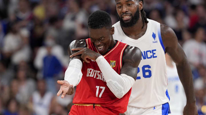 Aug 2, 2024; Villeneuve-d'Ascq, France; Germany point guard Dennis Schroder (17) celebrates after scoring as France centre Mathias Lessort (26) looks on in the second half in a men’s group B basketball game during the Paris 2024 Olympic Summer Games at Stade Pierre-Mauroy. Mandatory Credit: John David Mercer-USA TODAY Sports