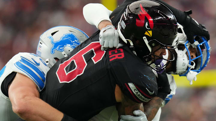 Arizona Cardinals running back James Conner (6) is tackled by Detroit Lions defenders Carlton Davis (23) and Jack Campbell (46) at State Farm Stadium in Glendale, Ariz., on Sep 22, 2024.