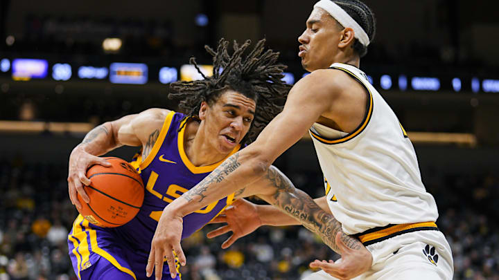 Jan 7, 2025; Columbia, Missouri, USA; LSU Tigers guard Dji Bailey (4) drives against Missouri Tigers guard Trent Pierce (11) during the second half at Mizzou Arena. Mandatory Credit: Jay Biggerstaff-Imagn Images