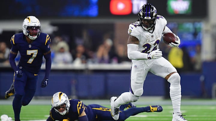 Nov 25, 2024; Inglewood, California, USA; Baltimore Ravens running back Derrick Henry (22) runs the ball ahead of Los Angeles Chargers cornerback Elijah Molden (22) during the second half at SoFi Stadium. Mandatory Credit: Gary A. Vasquez-Imagn Images