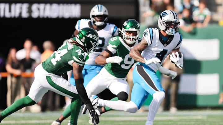 Oct 19, 2025; East Rutherford, New Jersey, USA; Carolina Panthers wide receiver Tetairoa McMillan (4) runs with the ball while being pursued by New York Jets defensive end Will McDonald IV (9) and linebacker Jamien Sherwood (44) in the second quarter at MetLife Stadium. Mandatory Credit: Vincent Carchietta-Imagn Images Oct 19, 2025; East Rutherford, New Jersey, USA; Carolina Panthers wide receiver Tetairoa McMillan (4) runs with the ball while being pursued by New York Jets defensive end Will McDonald IV (9) and linebacker Jamien Sherwood (44) in the second quarter at MetLife Stadium. Mandatory Credit: Vincent Carchietta-Imagn Images