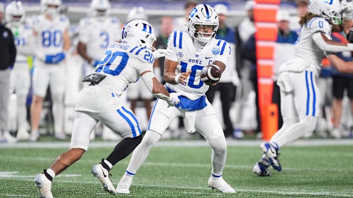 Dec 6, 2025; Charlotte, NC, USA; Duke Blue Devils quarterback Darian Mensah (10) hands off the ball in the second half against the Virginia Cavaliers during the 2025 ACC Championship. Dec 6, 2025; Charlotte, NC, USA; Duke Blue Devils quarterback Darian Mensah (10) hands off the ball in the second half against the Virginia Cavaliers during the 2025 ACC Championship.