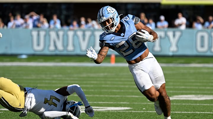Oct 12, 2024; Chapel Hill, North Carolina, USA;  North Carolina Tar Heels running back Omarion Hampton (28) with the ball as Georgia Tech Yellow Jackets defensive back Warren Burrell (4) defends in the fourth quarter at Kenan Memorial Stadium. Mandatory Credit: Bob Donnan-Imagn Images