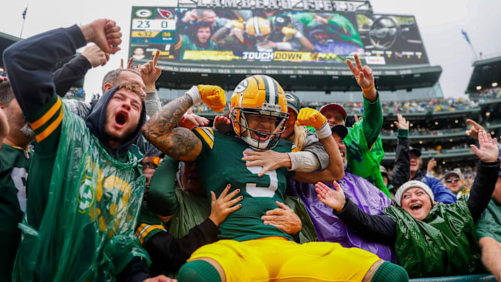 Green Bay Packers wide receiver Christian Watson celebrates with a Lambeau Leap after scoring against the Cardinals.