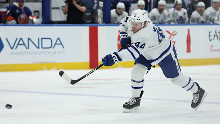 Jan 3, 2026; Elmont, New York, USA; Toronto Maple Leafs defenseman Morgan Rielly (44) takes a shot against New York Islanders during the first period at UBS Arena. Mandatory Credit: Thomas Salus-Imagn Images
