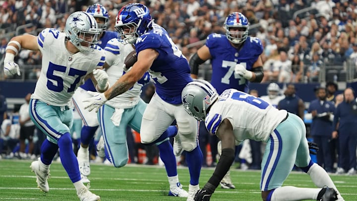 New York Giants RB Cam Skattebo runs with the ball as Dallas Cowboys LB Jack Sanborn and S Donovan Wilson defend.