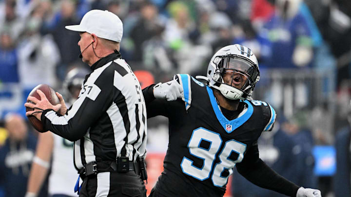 Dec 28, 2025; Charlotte, North Carolina, USA; Carolina Panthers linebacker D.J. Wonnum (98) tosses the ball to referee Carl Cheffers (51) and reacts after sacking Seattle Seahawks quarterback Sam Darnold (not pictured) during the fourth quarter at Bank of America Stadium. Mandatory Credit: Bob Donnan-Imagn Images